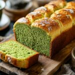 Fluffy matcha pan loaf sliced open on a wooden board