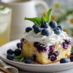 Slice of lemon blueberry sheet cake served with whipped cream