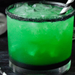 Layered Beetlejuice Cocktail with spooky decor