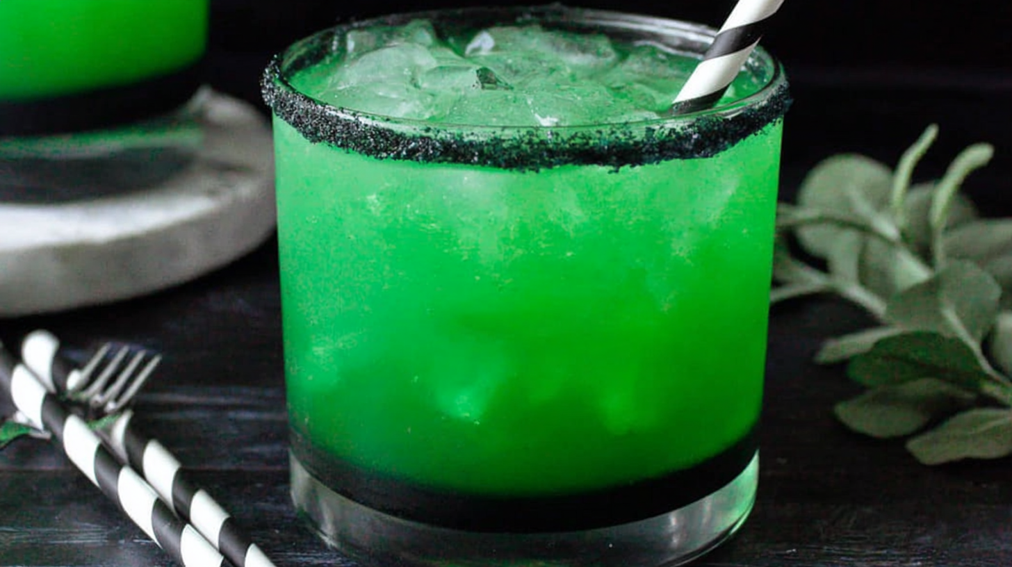 Layered Beetlejuice Cocktail with spooky decor