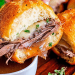 Cheesy French Dip Sliders with Au Jus on a Wooden Tray