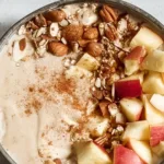 Delicious apple smoothie bowl topped with fresh fruits and nuts