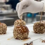 Delicious caramel apples drizzled with chocolate and topped with nuts