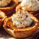 Mini pumpkin pies on a wooden table, decorated for fall.
