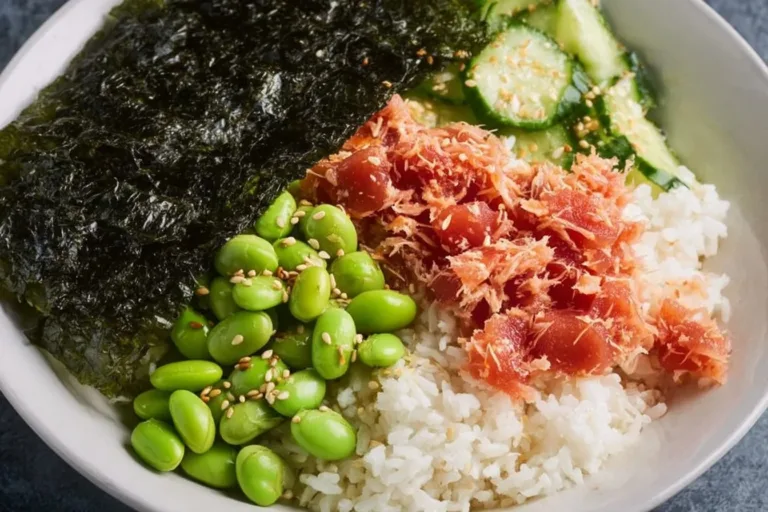 Spicy mayo tuna rice bowl garnished with vegetables and sesame seeds.