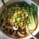 Bowl of Vegan Spicy Ramen topped with fresh vegetables and chili flakes