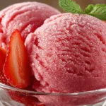Bowl of easy 3-ingredient strawberry sorbet topped with fresh strawberries.