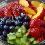 A vibrant bowl of assorted fresh fruit salad with various colors and textures.