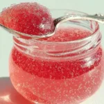 Jars of homemade rhubarb vanilla bean jelly on a wooden table