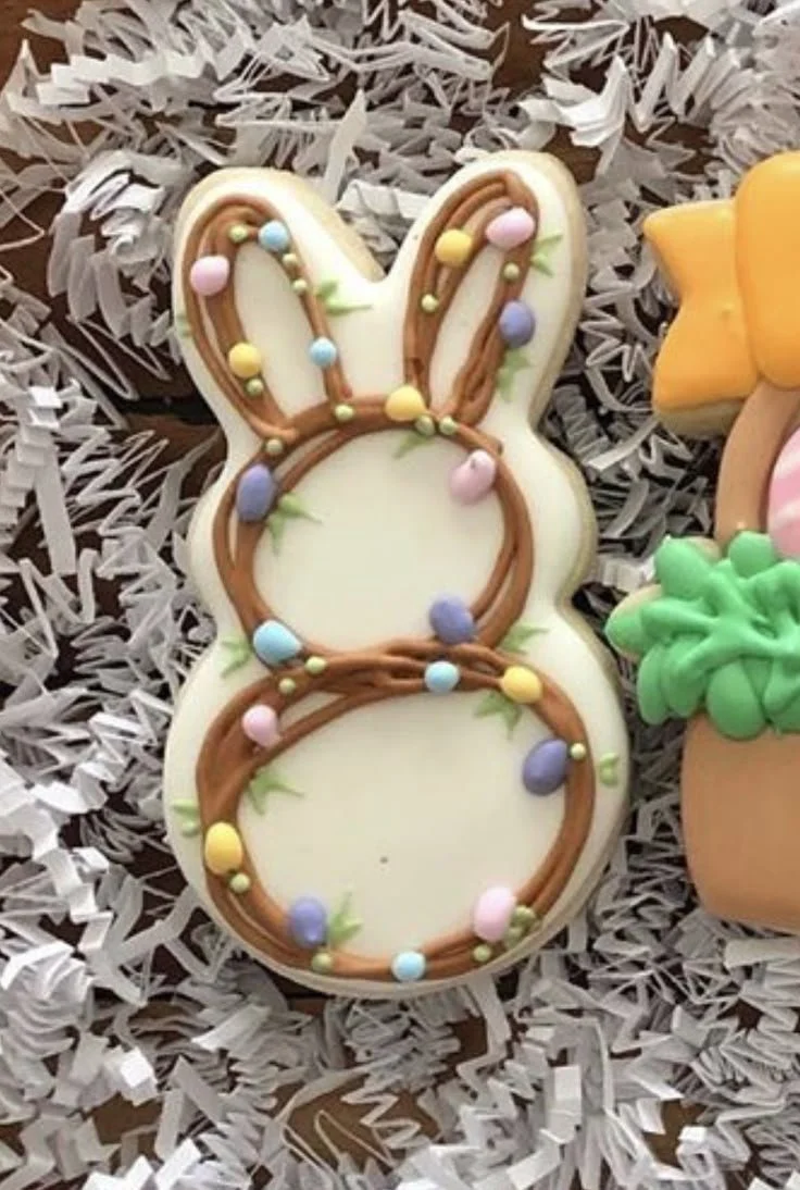 Colorful Easter sugar cookies decorated with icing and pastel designs on a platter.